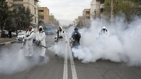 Members of firefighters wear protective face masks, amid fear of coronavirus disease (COVID-19), as they disinfect the streets, ahead of the Iranian New Year Nowruz, March 20, in Tehran, Iran March 18, 2020 - Sputnik International