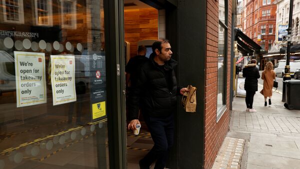 A man leaves a McDonald's restaurant in London as the spread of the coronavirus disease (COVID-19) continues, in London, Britain, March 18, 2020. - Sputnik International