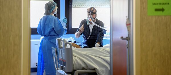 A medical worker wearing a protective mask and suit speaks with a patient suffering from coronavirus disease (COVID-19) in an intensive care unit at the Oglio Po hospital in Cremona, Italy, 19 March 2020. A medical worker wearing a protective mask and suit speaks with a patient suffering from coronavirus disease (COVID-19) in an intensive care unit at the Oglio Po hospital in Cremona, Italy, 19 March 2020. - Sputnik International