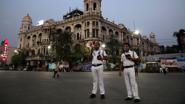 A police officer uses a megaphone, advising people to vacate the roads after the lockdown by the West Bengal state government, to limit the spreading of coronavirus disease (COVID-19), in Kolkata, India March 23, 2020 - Sputnik International