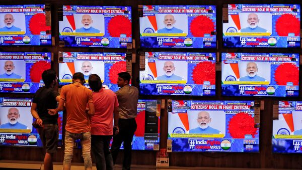 People watch Indian Prime Minister Narendra Modi addressing the nation amid concerns about the spread of coronavirus disease (COVID-19), on TV screens inside a showroom in Ahmedabad, India, March 19, 2020.  - Sputnik International