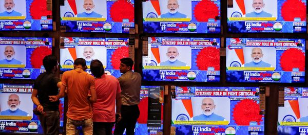 People watch Indian Prime Minister Narendra Modi addressing the nation amid concerns about the spread of coronavirus disease (COVID-19), on TV screens inside a showroom in Ahmedabad, India, March 19, 2020. People watch Indian Prime Minister Narendra Modi addressing the nation amid concerns about the spread of coronavirus disease (COVID-19), on TV screens inside a showroom in Ahmedabad, India, March 19, 2020. - Sputnik International