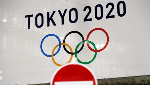 A banner for the upcoming Tokyo 2020 Olympics is seen behind a traffic sign, following an outbreak of the coronavirus disease (COVID-19), in Tokyo, Japan, March 23, 2020.  - Sputnik International