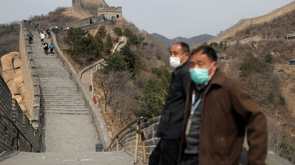 Men wearing protective masks stand as people hike along a section of the Great Wall in Badaling in Beijing, on its first day of re-opening after the scenic site's coronavirus related closure, China, 24 March 2020.  - Sputnik International