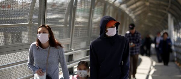 A family wearing protective face masks walks towards the U.S. at the Paso del Norte International Border bridge after the United States and Mexico have agreed to restrict non-essential travel over their shared border in an effort to limit the spread of the new coronavirus (COVID-19), in Ciudad Juarez, Mexico March 20, 2020. - Sputnik International