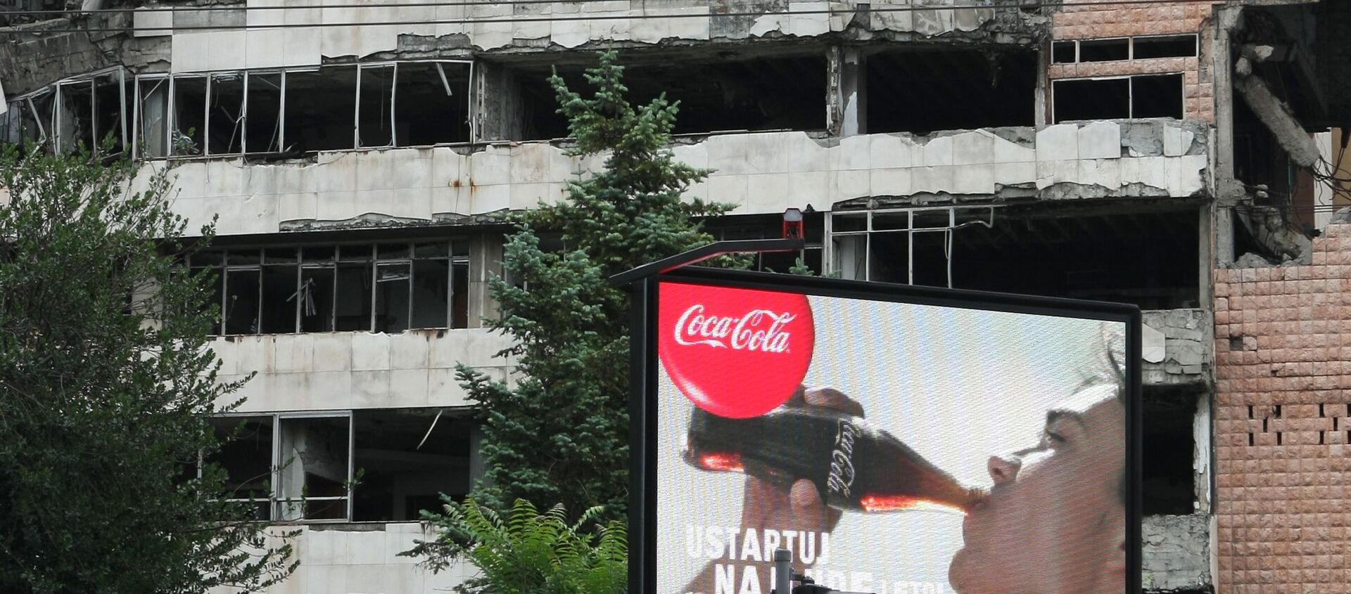 Coca Cola billboard in front of a building in Belgrade damaged during the 1999 NATO airstrikes. - Sputnik International, 1920, 24.03.2020