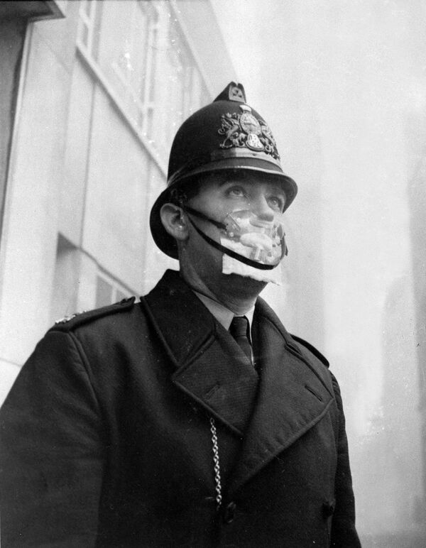 A British bobby, policeman, covers his mouth and nose with a mask to protect himself from the sulphurous smog in England on Dec. 5, 1962.  - Sputnik International
