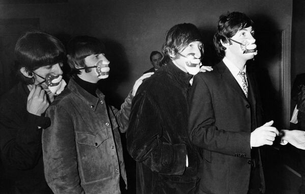 The Beatles are wearing the masks against the effects of fog. The famous beat group from Liverpool--George Harrison, Ringo Starr, John Lennon, and Paul McCartney , from left to right as they arrived for a concert in Ardwick, Manchester,  December 7, 1965  wearing masks.  - Sputnik International