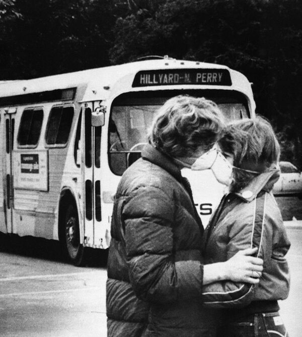 Fifteen-year-old Heidi Havens gives Allen Troup, 16, a kiss as he prepares to board a Spokane City bus, May 27, 1980. Spokane residents have had to wear face masks while outside for days now because of possible health threats from volcanic ash sprayed over the area by Mount St. Helens - Sputnik International