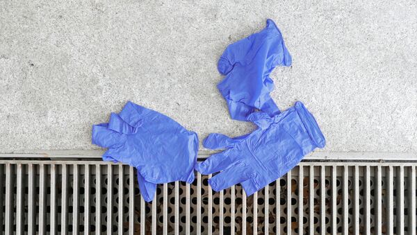 Discarded latex gloves lay across a walkway at the U.S. Capitol ahead of a Senate lunch meeting on response to the coronavirus disease (COVID-19) on Capitol Hill in Washington, U.S., March 19, 2020. - Sputnik International
