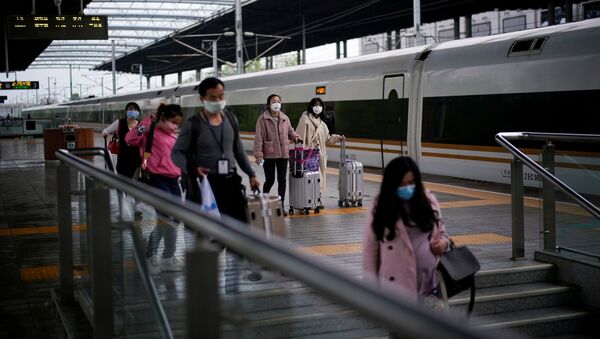 Passengers wearing face masks travel with their belongings at a railway station in Xianning of Hubei province, the epicentre of China's coronavirus disease (COVID-19) outbreak, March 25, 2020. REUTERS/Aly Song - Sputnik International