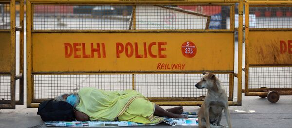 A homeless person sleeps on the pavement outside a railway station during a 21-day nationwide lockdown to limit the spreading of coronavirus disease (COVID-19), in New Delhi, India, March 26, 2020.  - Sputnik International