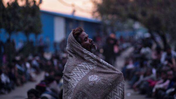 A homeless man waits for food outside a government-run night shelter during a 21-day nationwide lockdown to limit the spreading of coronavirus disease (COVID-19), in New Delhi, India, March 25, 2020.  - Sputnik International