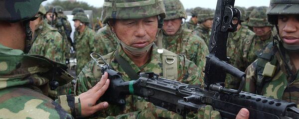 American Soldiers demonstrate the M-249 Squad Automatic Weapon to a Japanese soldier of the 39th Infantry Regiment, Japan Ground Self-Defense Force, during Exercise Orient Shield - Sputnik International