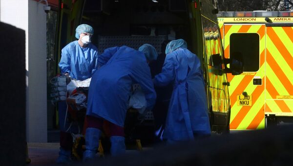 Medical staff with a patient at the back of ambulance outside St Thomas' hospital, as the spread of the coronavirus disease (COVID-19) continues, London, Britain, March 26, 2020. - Sputnik International