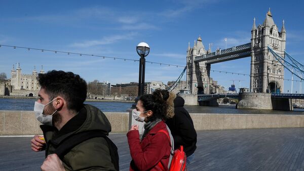 People wearing masks infront of Tower Bridge as the spread of the coronavirus disease (COVID-19) continues, in London, Britain, March 23, 2020. - Sputnik International