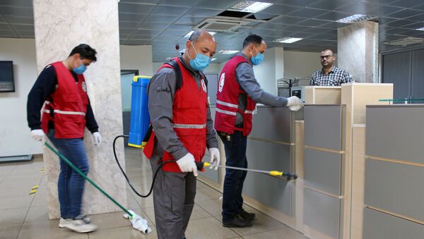 Members of Red Crescent spray disinfectants, as part of precautionary measures against coronavirus disease (COVID-19) at government offices in Misrata, Libya March 21, 2020. Picture taken March 21, 2020 - Sputnik International