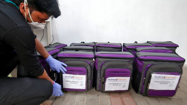 A laboratory technician places a tag on a box containing coronavirus disease (COVID-19) testing kit at a sample collection centre in Ahmedabad, India March 26, 2020. - Sputnik International