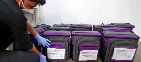 A laboratory technician places a tag on a box containing coronavirus disease (COVID-19) testing kit at a sample collection centre in Ahmedabad, India March 26, 2020. - Sputnik International