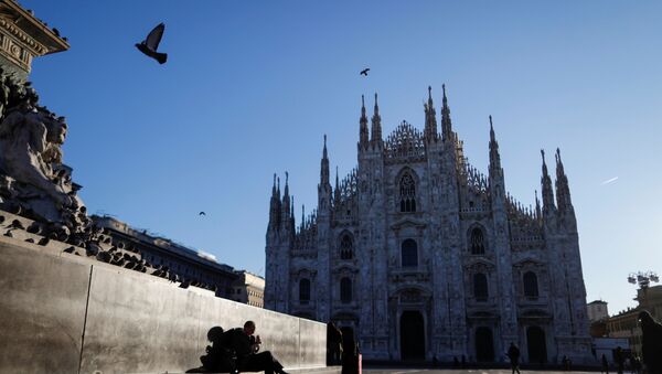 People walk through a near-empty Duomo square, usually full of people, as a coronavirus outbreak in northern Italy continues to grow, in Milan, Italy February 28, 2020. - Sputnik International