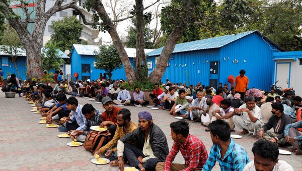Daily wage workers and homeless people eat food inside a government-run night shelter during a 21-day nationwide lockdown to limit the spreading of coronavirus disease (COVID-19), in the old quarters of Delhi, India, March 26, 2020. - Sputnik International