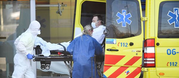 Dutch health workers leave with a patient at Bernhoven hospital, - Sputnik International