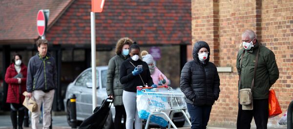 People wearing protective facemasks queue outside Sainsbury's supermarket in Streatham - Sputnik International