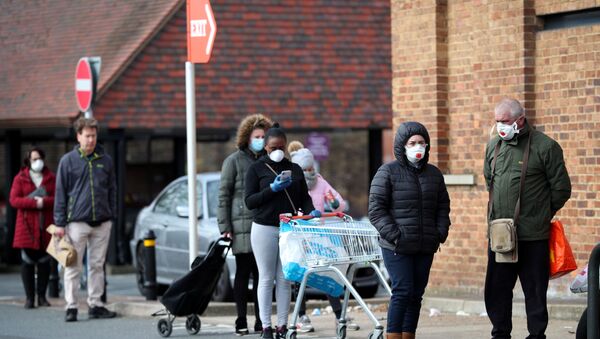 People wearing protective facemasks queue outside Sainsbury's supermarket in Streatham - Sputnik International
