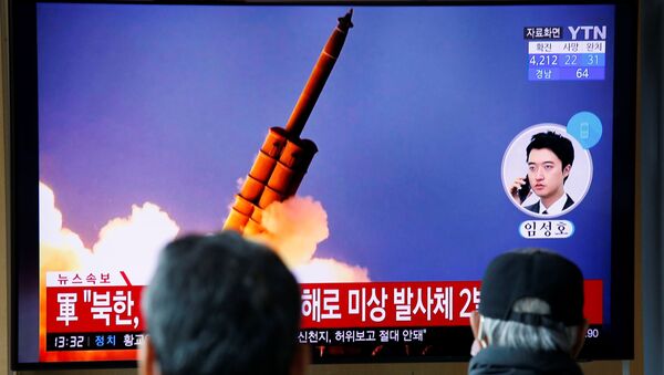People watch a TV showing a file picture for a news report on North Korea firing two unidentified projectiles, in Seoul, South Korea, March 2, 2020. - Sputnik International