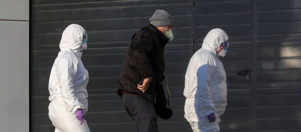 Medical staff members wearing protective suits accompany a man at a hospital, where coronavirus disease (COVID-19) patients are being treated, in Moscow, Russia March 17, 2020 Medical staff members wearing protective suits accompany a man at a hospital, where coronavirus disease (COVID-19) patients are being treated, in Moscow, Russia March 17, 2020 - Sputnik International