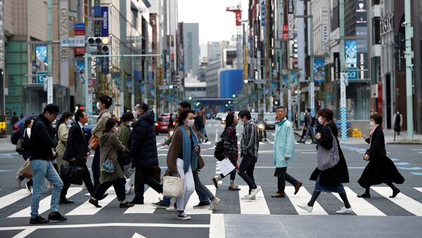 Passersby wearing protective face masks, following an outbreak of the coronavirus disease (COVID-19), are seen at Ginza shopping district during the first weekend after Tokyo Governor Yuriko Koike (not pictured) urged Tokyo residents to stay indoors in a bid to keep a coronavirus from spreading, in Tokyo, Japan March 28, 2020.  - Sputnik International