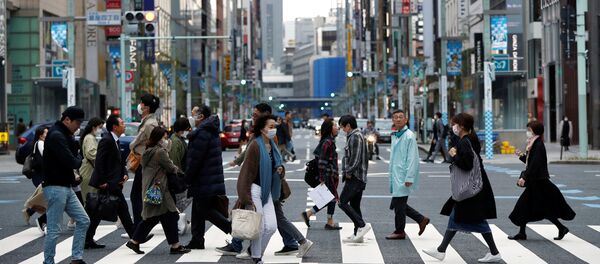 Passersby wearing protective face masks, following an outbreak of the coronavirus disease (COVID-19), are seen at Ginza shopping district during the first weekend after Tokyo Governor Yuriko Koike (not pictured) urged Tokyo residents to stay indoors in a bid to keep a coronavirus from spreading, in Tokyo, Japan March 28, 2020.  - Sputnik International