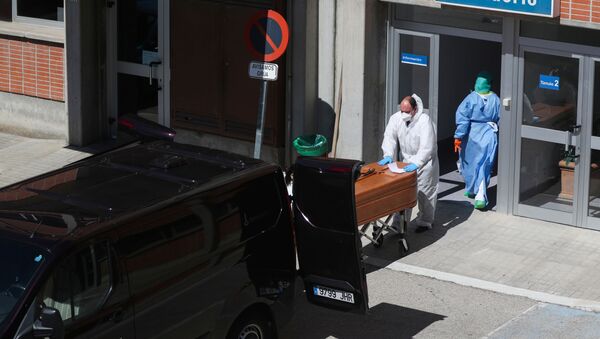 A funeral worker wearing a protective suit carries a coffin out of the morgue at Severo Ochoa Hospital, during the coronavirus disease (COVID-19) outbreak in Leganes, Spain, March 26, 2020 - Sputnik International