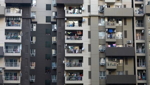 Residents clap and bang utensils from their balconies to cheer for emergency personnel and sanitation workers who are on the frontlines in the fight against coronavirus, in Noida, India, March 22, 2020 - Sputnik International