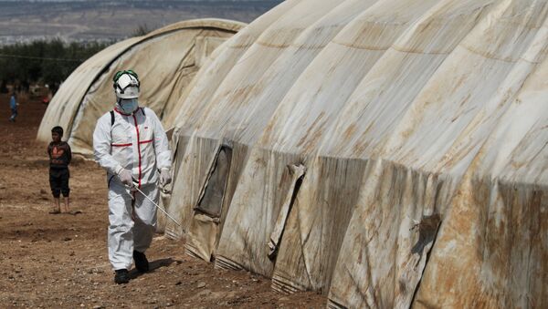 A member of the Syrian Civil defence sanitizes a tent at the Bab Al-Nour internally displaced persons camp, to prevent the spread of coronavirus disease (COVID-19) in Azaz, Syria 26 March 2020. - Sputnik International