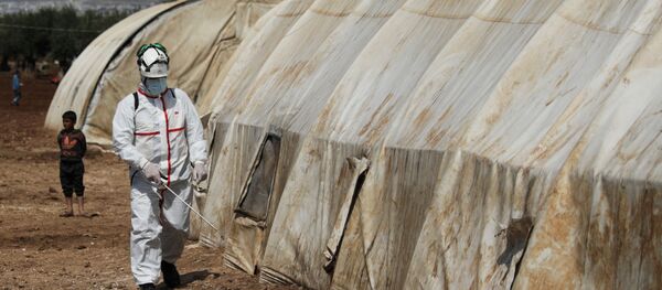 A member of the Syrian Civil defence sanitizes a tent at the Bab Al-Nour internally displaced persons camp, to prevent the spread of coronavirus disease (COVID-19) in Azaz, Syria 26 March 2020. - Sputnik International
