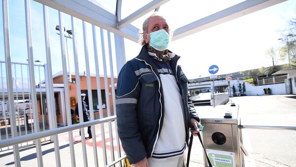 Fiat Chrysler Automobiles (FCA) worker, wearing a protective face mask, leaves a Mirafiori plant, after the Italian government puts the whole country on lockdown as new coronavirus cases surge, in Turin, Italy March 10, 2020 - Sputnik International