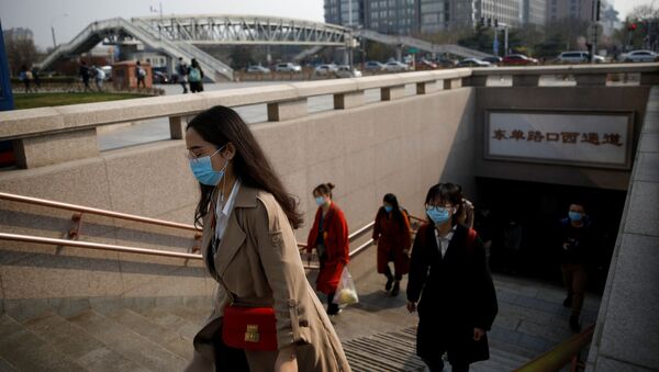 People wearing face masks exit a subway station following an outbreak of the coronavirus disease (COVID-19), in Beijing, China 30 March 2020. - Sputnik International