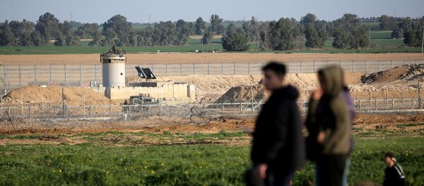 An Israeli watchtower is seen as Palestinians stand at the Israel-Gaza border fence in the southern Gaza Strip, 28 February 2020.   - Sputnik International
