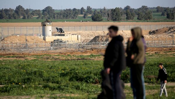 An Israeli watchtower is seen as Palestinians stand at the Israel-Gaza border fence in the southern Gaza Strip, 28 February 2020.   - Sputnik International