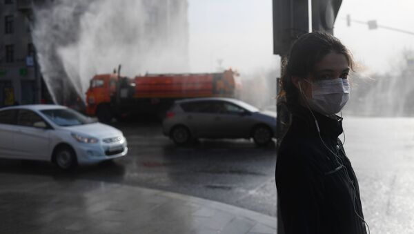 A girl in a medical mask stands at the crossing in Moscow - Sputnik International