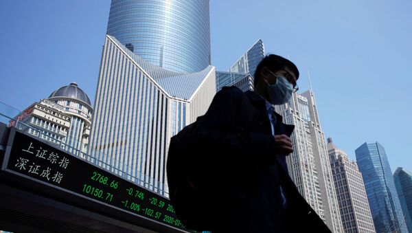 A pedestrian wearing a face mask walks near an overpass with an electronic board showing stock information, following an outbreak of the coronavirus disease (COVID-19), at Lujiazui financial district in Shanghai, China March 17, 2020.  - Sputnik International