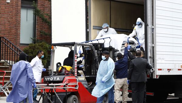 Workers load deceased person into truck trailer outside Brooklyn Hospital Center during the coronavirus disease (COVID-19) in New York - Sputnik International