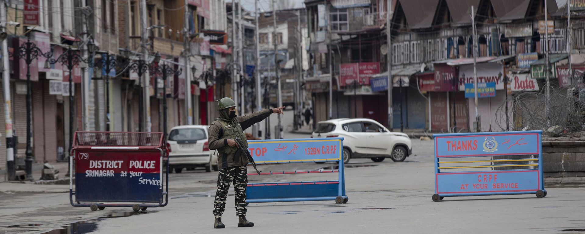 An Indian paramilitary soldier gestures towards a Kashmiri man during lockdown in Srinagar, Indian controlled Kashmir, Wednesday, March 25, 2020 - Sputnik International, 1920, 21.09.2021