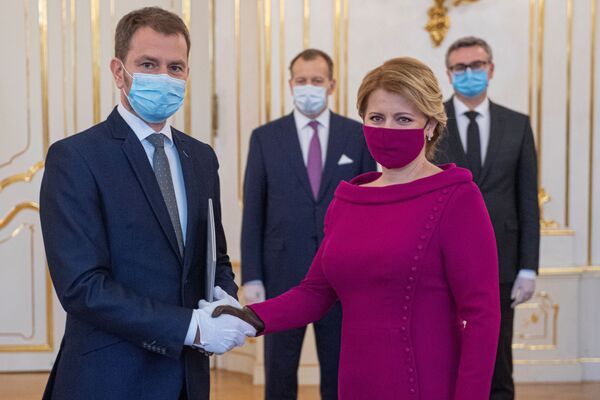 Slovakia's President Zuzana Caputova and Prime Minister Igor Matovic wearing protective face masks shake hands as they attend the cabinet's inauguration at Presidential Palace in Bratislava, Slovakia March 21, 2020.  - Sputnik International