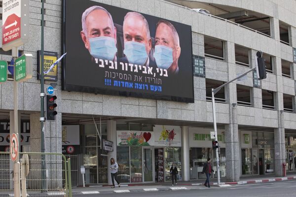 A billboard shows Israeli Prime Minister Benjamin Netanyahu, left, Israeli Former Defense Minister and leader of the Yisrael Beiteinu (Israel Our Home) right-wing party Avigdor Lieberman, center, and Blue and White party leader Benny Gantz, wearing masks in the Israeli city of Ramat Gan, near Tel Aviv, Sunday, March 29, 2020.  - Sputnik International