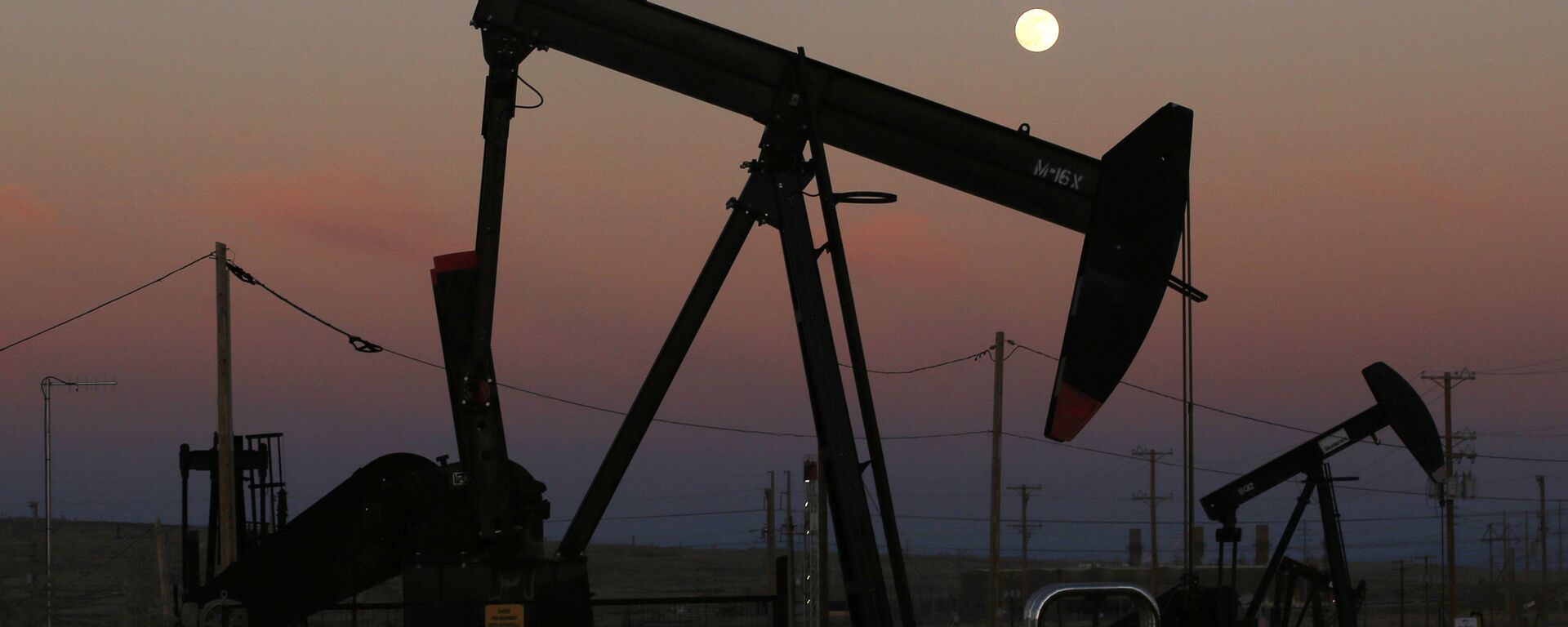 FILE - In this June 8, 2017, file photo, oil derricks are busy pumping as the moon rises near the La Paloma Generating Station in McKittrick, Calif. The U.S. is on pace to leapfrog both Saudi Arabia and Russia as the world’s biggest oil producer - Sputnik International, 1920, 05.06.2023
