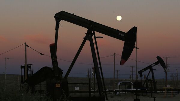 FILE - In this June 8, 2017, file photo, oil derricks are busy pumping as the moon rises near the La Paloma Generating Station in McKittrick, Calif. The U.S. is on pace to leapfrog both Saudi Arabia and Russia as the world’s biggest oil producer - Sputnik International