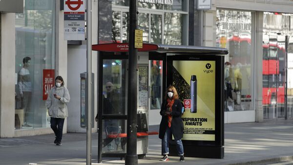 A woman waits at a bus stop in London's deserted Oxford Street - Sputnik International