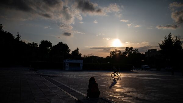 A woman sits outside the Panathenaic stadium, during a nationwide lockdown to contain the spread of the coronavirus disease (COVID-19), in Athens, Greece, 29 March 2020. - Sputnik International
